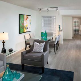 Open concept living and dining area with track lighting and wood look flooring