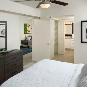 Bedroom with ensuite bathroom ceiling fan and carpet flooring