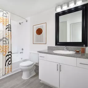 Bathroom with framed mirror and curved shower rod at Camden Portofino apartments in Pembroke Pines, FL