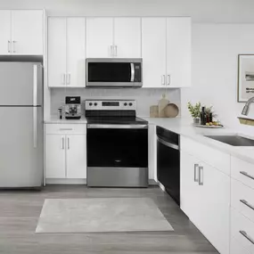 Modern interior finishes with white cabinets, stainless steel appliances and white quartz countertops in the alberti floorplan at camden portofino in pembrooke pines, fl.