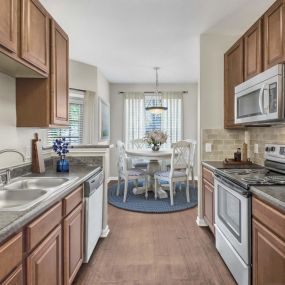 Kitchen and dining area with wood-look flooring and adjacent dining area