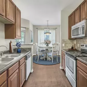 Kitchen and dining area with wood-look flooring and adjacent dining area