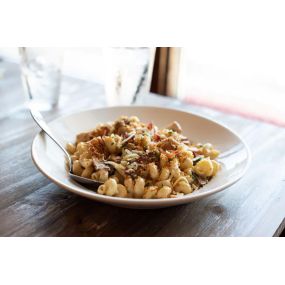 At Tipsy Chicken Kitchen & Cocktails, we offer Rooster Mac & Cheese! We start with Cavatappi noodles covered in creamy cheese sauce with pulled chicken breast, bacon, and mushrooms topped with bread crumbs.  If you like some spice ask them to toss in buffalo bleu for you!