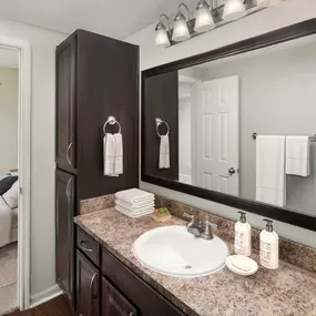 Bathroom with dark espresso cabinets and framed mirror