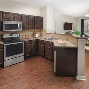 Kitchen and living room with dark espresso cabinetry and wood-style flooring throughout