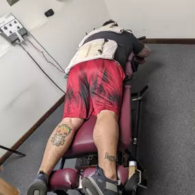 Man laying on a chiropractic table with relief pads on his back