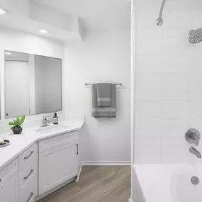 Bathroom with white countertops, white cabinets and a soaking tub with white tile surround at Camden Gaines Ranch