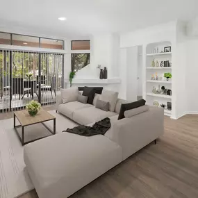 Living room with light gray wood-style floors, fireplace and large windows showing a spacious patio at Camden Gaines Ranch