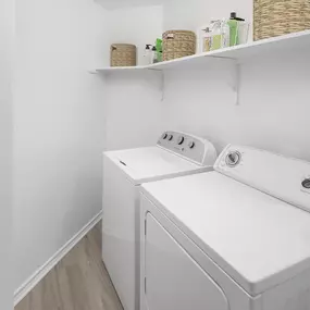 Laundry room with washer and dryer and built-in shelf at Camden Gaines Ranch