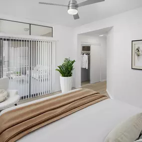 Primary bedroom with wood-style floors, modern ceiling fan, and patio access at Camden Gaines Ranch apartments in Austin, TX
