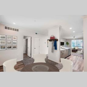 Flexible dining room near entry way with wood-style flooring and open-concept kitchen with white quartz countertops