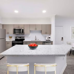 Stainless steel appliances and white quartz kitchen island at Camden Landmark Apartments in Ontario CA