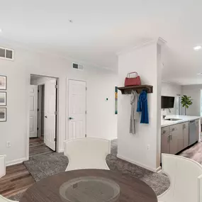 Flexible dining room near entry way with wood-style flooring and open-concept kitchen with white quartz countertops