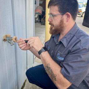 Tech repairing a hose bibb