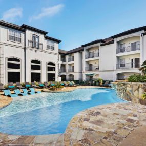 Resort-style pool with sun loungers and water feature at Camden Midtown Apartments in Houston, TX