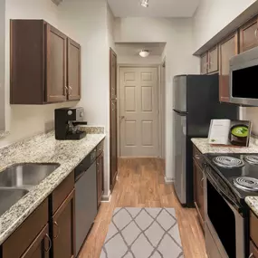 kitchen with granite countertops and stainless steel appliances at Camden Midtown Apartments in Houston, TX