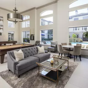 Resident clubroom with views of the resort-style pool, billiards, shuffle board and a fireplace at Camden Midtown Apartments in Houston, TX