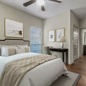 Bedroom with ensuite bath desk space and wood look flooring