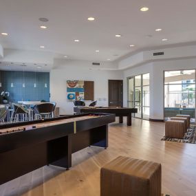 Resident clubhouse with shuffleboard and kitchen and dining seating