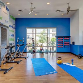 24-hour fitness center with spin bikes, stability balls, and space for pilates and yoga