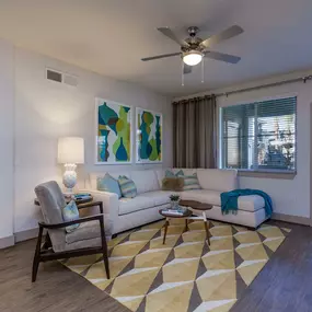 Open concept living room with wood style floor and lighted ceiling fan and patio access