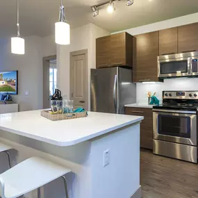 Kitchen with stainless steel appliances and island with space for bar stool seating