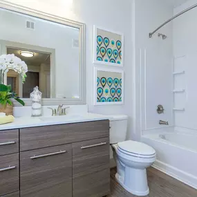 Bathroom with white quartz countertop and bathtub with curved shower rod