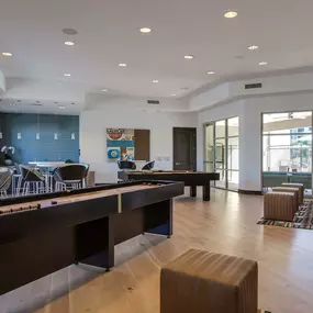 Resident clubhouse with shuffleboard and kitchen and dining seating