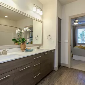 Ensuite bathroom with white quartz countertops double sink vanity and wood style floor