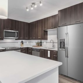 Kitchen with white quartz countertops, pendant lighting, and sleek gray cabinets