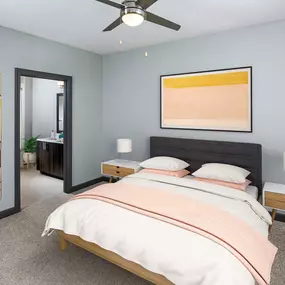 Bedroom with ensuite bath, carpet flooring, and ceiling fan