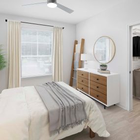 First-floor bedroom with wood-style flooring and attached walk-in closet