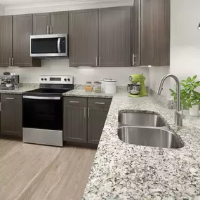 Kitchen with granite countertops, brown cabinets and stainless steel appliances