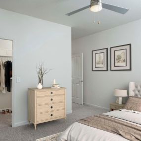 Bedroom with lighted ceiling fan and spacious walk in closet