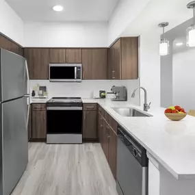 Kitchen with quartz countertops and stainless steel appliances at Camden Vanderbilt Apartments in Houston, TX.