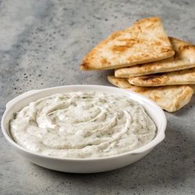 Tzatziki and Pita - Our popular yogurt-based sauce with cucumber, garlic, and fresh herbs – served with pita bread.