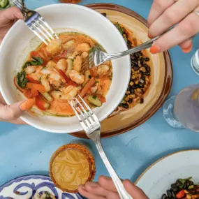 People passing a plate of ceviche