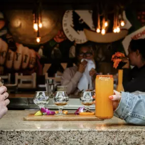 People sitting at the bar drinking craft cocktails