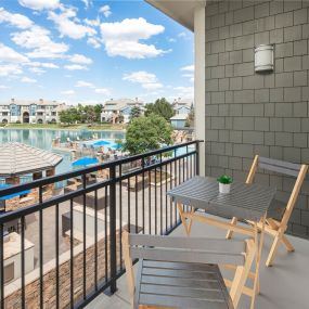 Modern finish in floor plan 9 balcony overlooking the pool and lake with seating at Camden Lakeway Apartments in Lakewood, CO
