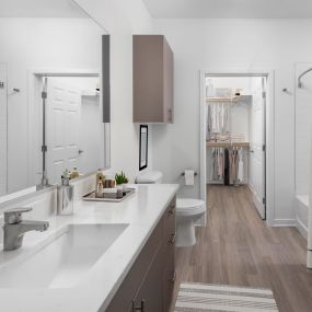 Modern finish bathroom with white quartz countertops, greige cabinetry, stand-up shower, and soaking bathtub.