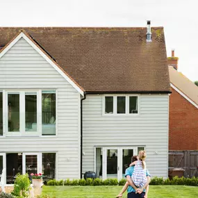 Large home with siding installation and man standing in front yard