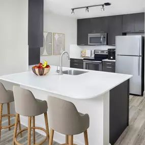 Kitchen with bar seating at Camden North Quarter apartments in Orlando, FL