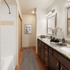 Double vanity ensuite bathroom with granite countertops at Camden Greenway Apartments in Houston, TX