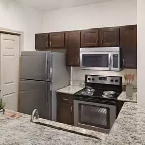 Kitchen with stainless steel appliances and granite countertops at Camden Greenway Apartments in Houston, TX