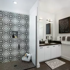 Bathroom with decorative tile glass enclosed shower and double sink vanity