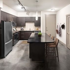 Urban style kitchen with black granite countertops and cement flooring