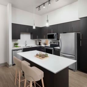 Modern-style kitchen with white countertops and brown cabinets at Camden Belmont apartments in Dallas, Tx