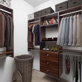 Walk-in closet with wood-style floors at built-in shelves and drawers at Camden Belmont apartments in Dallas, Tx