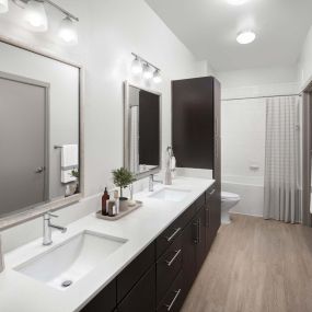 Modern-style bathroom with two sinks and white quartz countertops at Camden Belmont apartments in Dallas, Tx