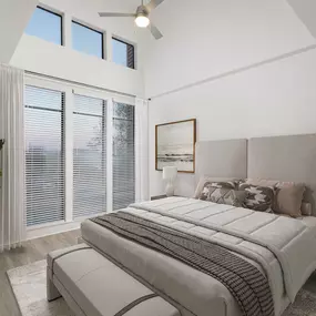 Townhome primary bedroom with extended ceilings, wood-style flooring, and tall windows at Camden Belmont apartments in Dallas, TX